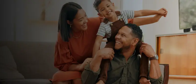 Família brincando e sorrindo na sala de casa